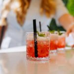 Gen Z Rejection Triggers MASSIVE Bar Transformation Close-up of cocktails on a table with a person reaching for one