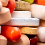 New Allergy Drug Protects Against 5 Foods! A close-up view of a variety of colorful pills and tablets stacked together