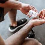 Pre-Workout Powder’s Sleep Sabotage Person pouring probiotic pills into their hand