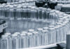Close-up of glass vials arranged in a circular conveyor system in a pharmaceutical setting