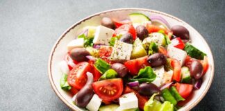 A vibrant salad with tomatoes, cucumbers, olives, and feta cheese