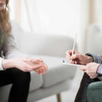 Declutter Chaos: 5 Tips for Mental Peace Two individuals engaged in a counseling session, one taking notes