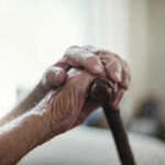 The Best Lifespan Predictor Close-up of elderly hands resting on a cane