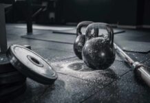 Post-Workout Hacks Trainers Don’t Tell You Kettlebells and weights on a gym floor with chalk dust