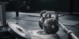 Kettlebells and weights on a gym floor with chalk dust