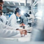 Alzheimer’s Clue Found in Diabetic Teens Scientists working in a laboratory with microscopes and test tubes