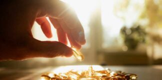 A hand reaching for a golden capsule among many on a table