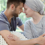 A couple sharing a tender moment, foreheads touching, in a cozy setting