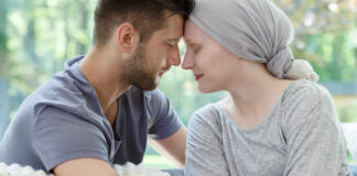A couple sharing a tender moment, foreheads touching, in a cozy setting