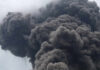 Thick dark smoke billowing into the sky