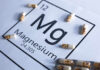 Magnesium element symbol with colorful capsules arranged around it
