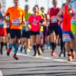The 100-Mile Summer Fitness Phenomenon A group of runners participating in a marathon on a sunny day