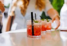 Close-up of cocktails on a table with a person reaching for one