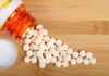 Pain Pills After 60: Hidden Heart Trap? Spilled white pills from a prescription bottle on a wooden surface