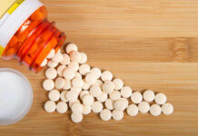 Pain Pills After 60: Hidden Heart Trap? Spilled white pills from a prescription bottle on a wooden surface