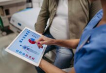 Australia’s National Cancer Scorecard Shocks World Nurse showing a patient health data on a tablet