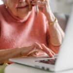 Longevity Hack Hiding In One Immune Gene Elderly woman on a phone call while using a laptop