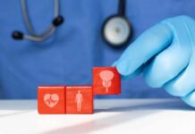 Mayo Clinic Drops Pill-Free Inflammation Playbook A doctor's gloved hand placing red blocks with health symbols on a table