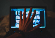 Blue Light – Villain? Only Half True A hand reaching towards a laptop screen displaying various images