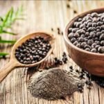 This Grain Could Help Protect Your Brain As You Age Black peppercorns in a wooden bowl and spoon with ground pepper