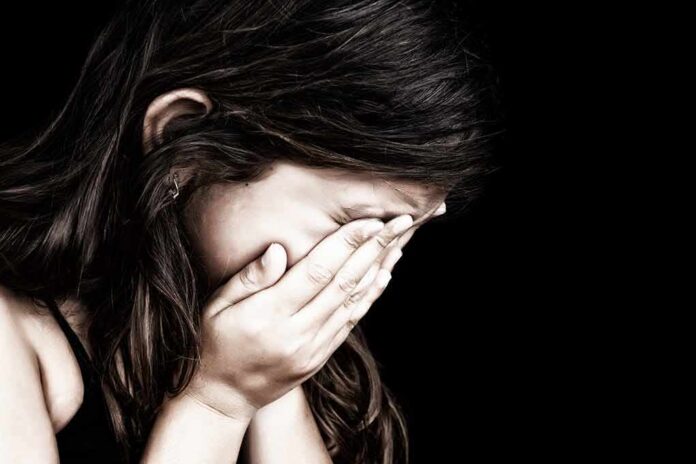 Child covering face with hands