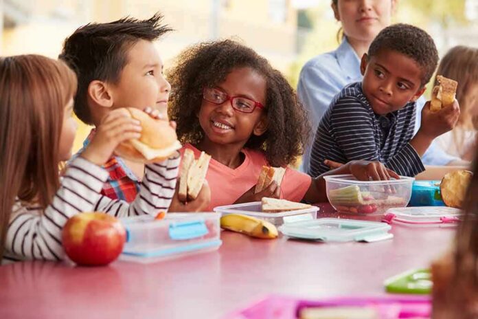 shutterstock_1177724494 children eating lunch at a table