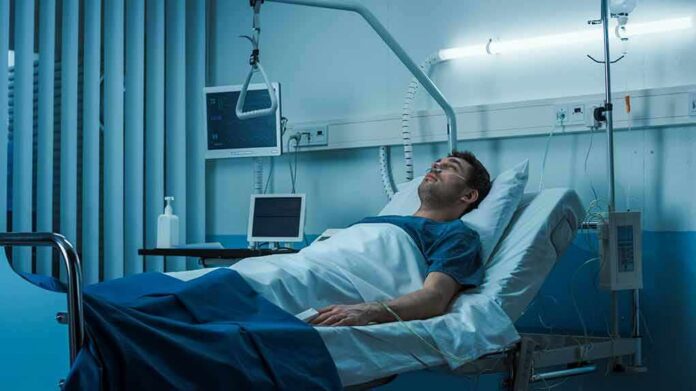 Man lying in a hospital bed with monitors and IV equipment