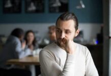 One-In-Five Crisis: The Lonely America man sitting alone in a cafe looking to the side