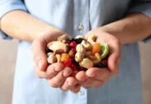 Hands holding mixed nuts and dried fruit