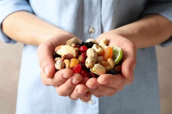 Hands holding mixed nuts and dried fruit