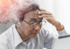 Elderly man looking stressed while using a digital device