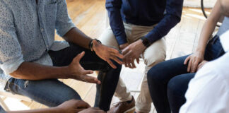 A group of people engaged in a discussion with hands gesturing expressively