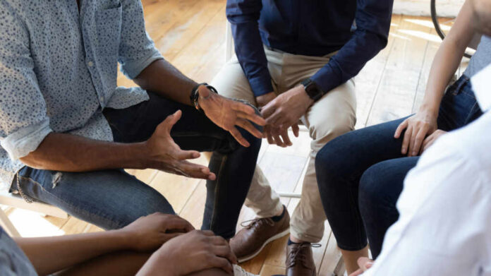 shutterstock_1477336916 A group of people engaged in a discussion with hands gesturing expressively