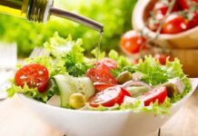 Fresh salad being drizzled with olive oil