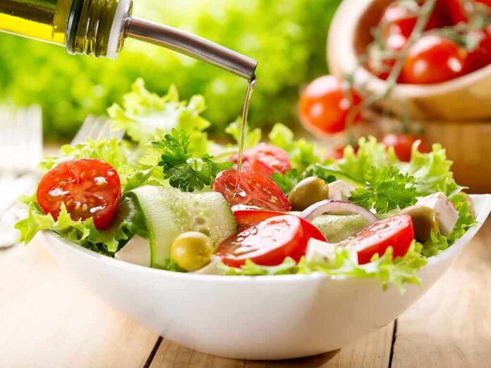 shutterstock_162229250 Fresh salad being drizzled with olive oil