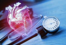 Tiny Mouth Bacteria Increasing Your Heart Disease Risk An anatomical heart illustration next to a blood pressure monitor