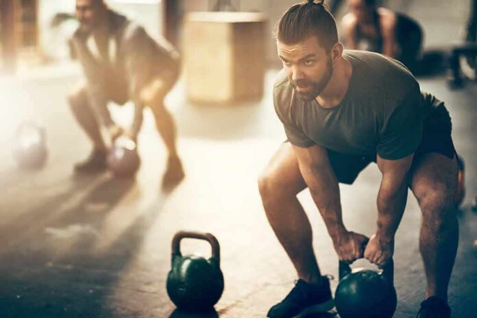 1783890389245-2xzjhz-shutterstock-1043370892 Man lifting a kettlebell in a gym