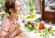 Deadly Nutrient Deficit Hiding In Healthy Diets Woman eating a fresh salad at a bright cafe
