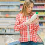 Midlife Menu – Late-Life Mood Shift? Woman reading a bottle label in a grocery store aisle