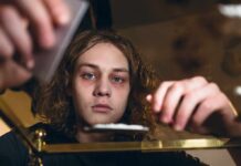 Why The Wrong Zip Code Derails Addiction Recovery young person leaning over a table with hands arranging items