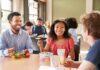 Students eating lunch together at a cafeteria table