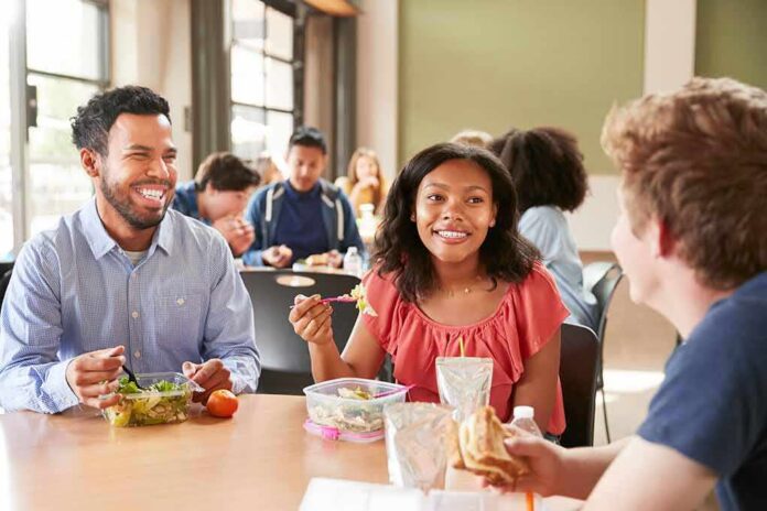 Students eating lunch together at a cafeteria table