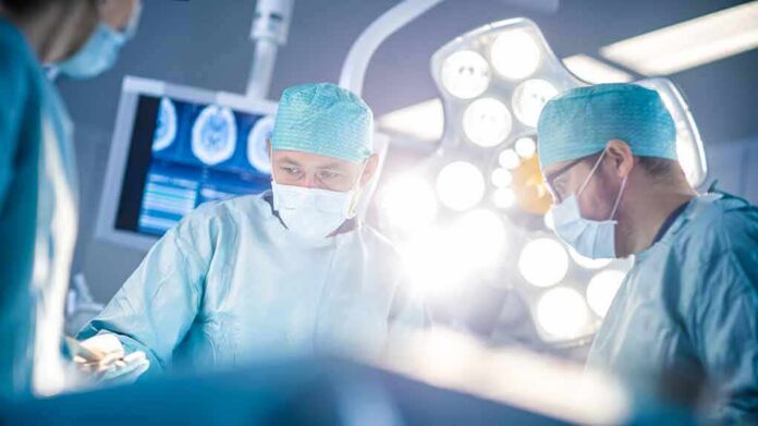 Surgeons in operating room under bright surgical lights