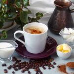Berries, Cocoa, Coffee: The Recovery Hack Cup of coffee with milk, butter, and spices on a table