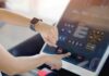 Clock-Driven Workout For Quicker Muscle Growth Person using a treadmill touchscreen with a smartwatch