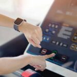 Clock-Driven Workout For Quicker Muscle Growth Person using a treadmill touchscreen with a smartwatch