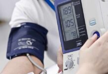 Silent Dinner Habit That Spikes Blood Pressure Person having blood pressure measured with digital monitor