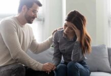 Man comforting a distressed woman on a couch