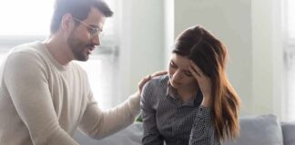 Man comforting a distressed woman on a couch