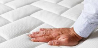 Hand pressing a quilted white mattress surface